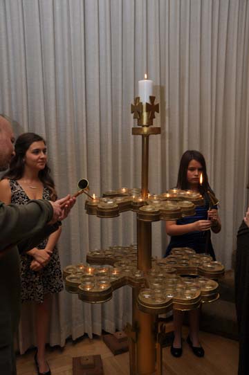 Acolytes Sonya and Sabrina Savoy assist Community members to light candles of remembrance. PHOTO: Stephan Fuelling