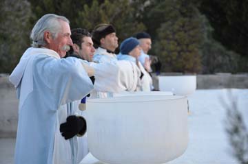 Concelebrants play "singing" bowls at sunrise